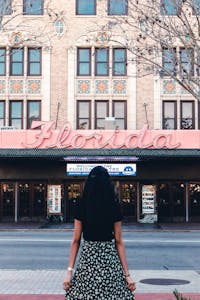 A woman in black stands outside the historic Florida Theatre, Jacksonville.