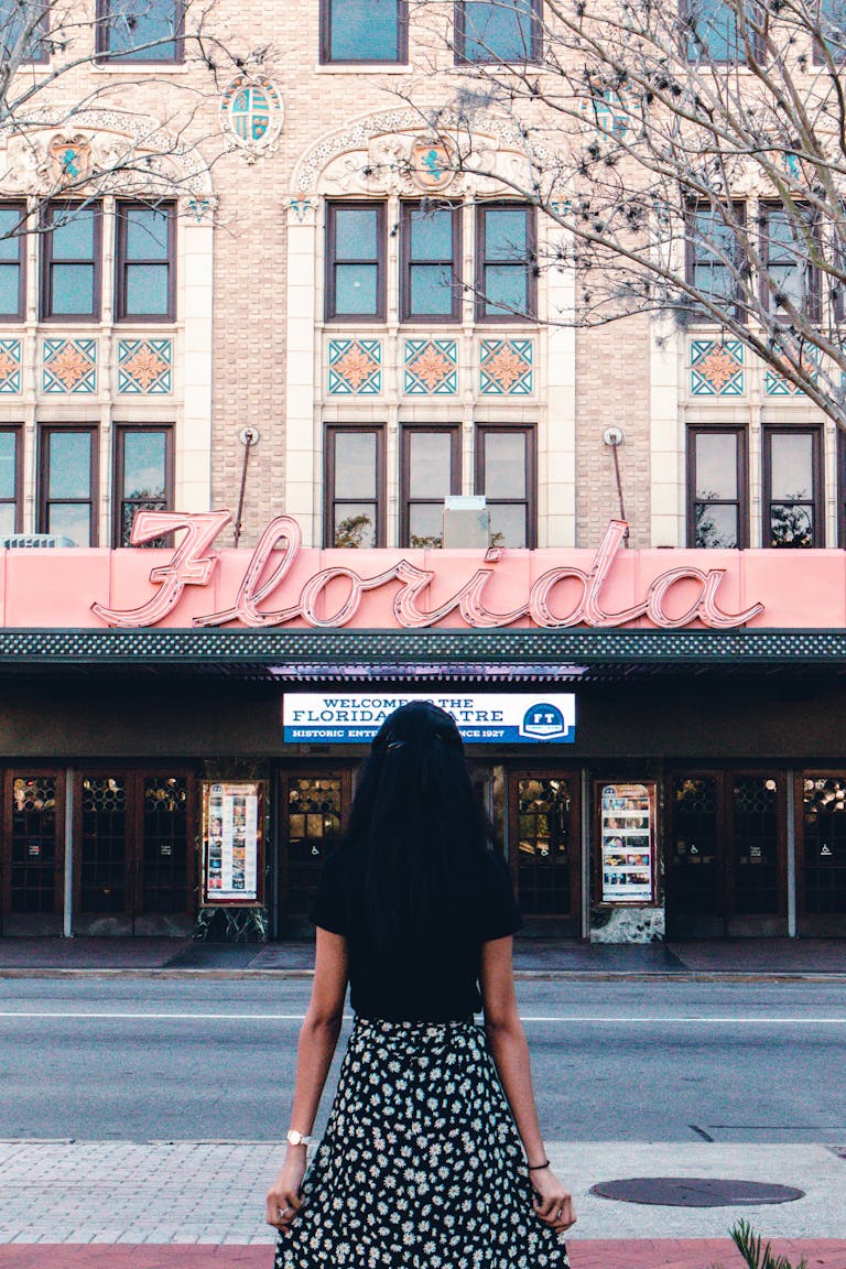 A woman in black stands outside the historic Florida Theatre, Jacksonville.