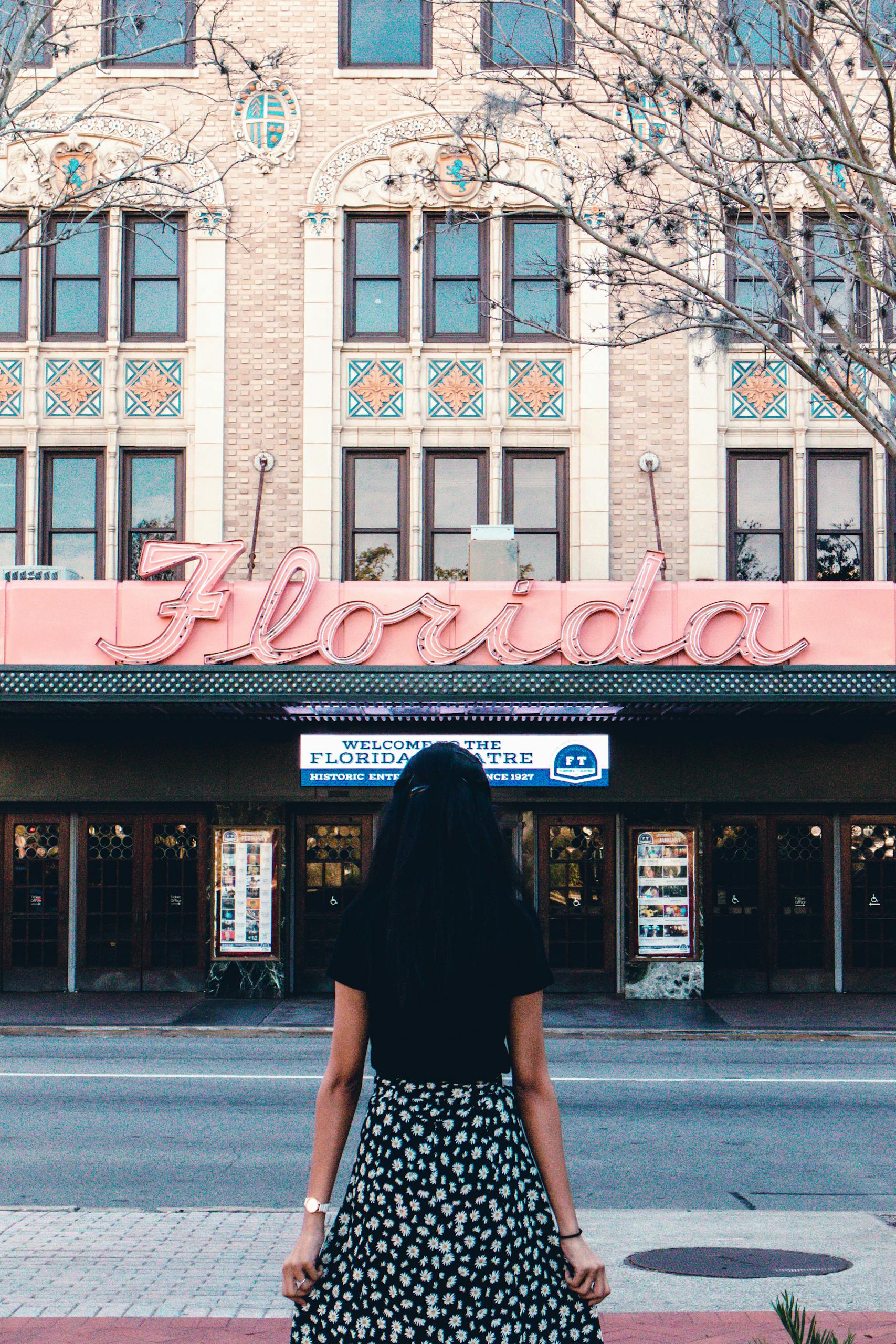 A woman in black stands outside the historic Florida Theatre, Jacksonville.